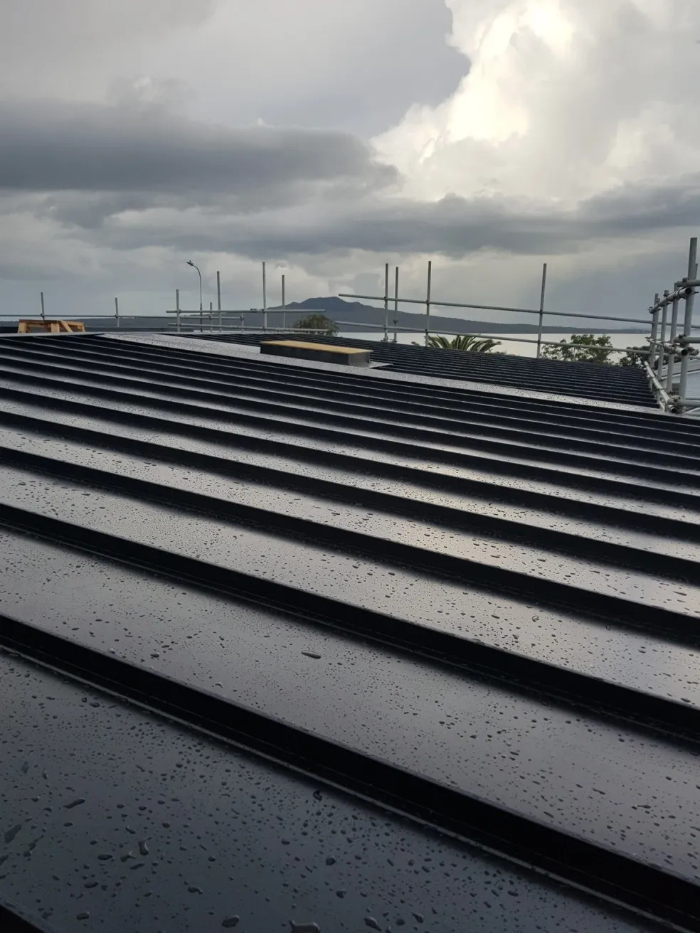 dark ribbed metal roof and cladding under a moody sky